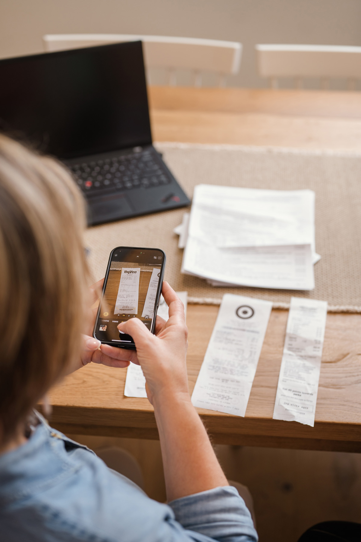 woman taking pictures of tax documents and receipts with iphone